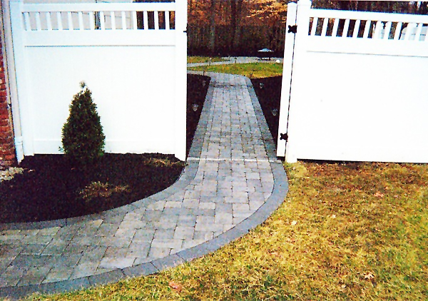 paved walkway through fence